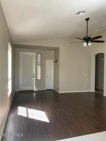 a view of an empty room with window and wooden floor