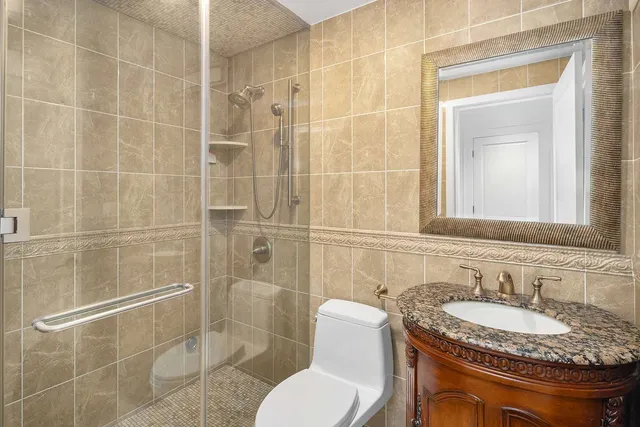 a bathroom with a granite countertop sink toilet a mirror and shower