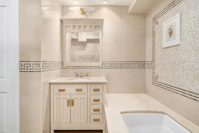 a bathroom with a granite countertop sink a toilet and a mirror