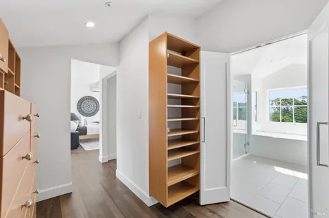 a view of a hallway with bathroom and wooden floor