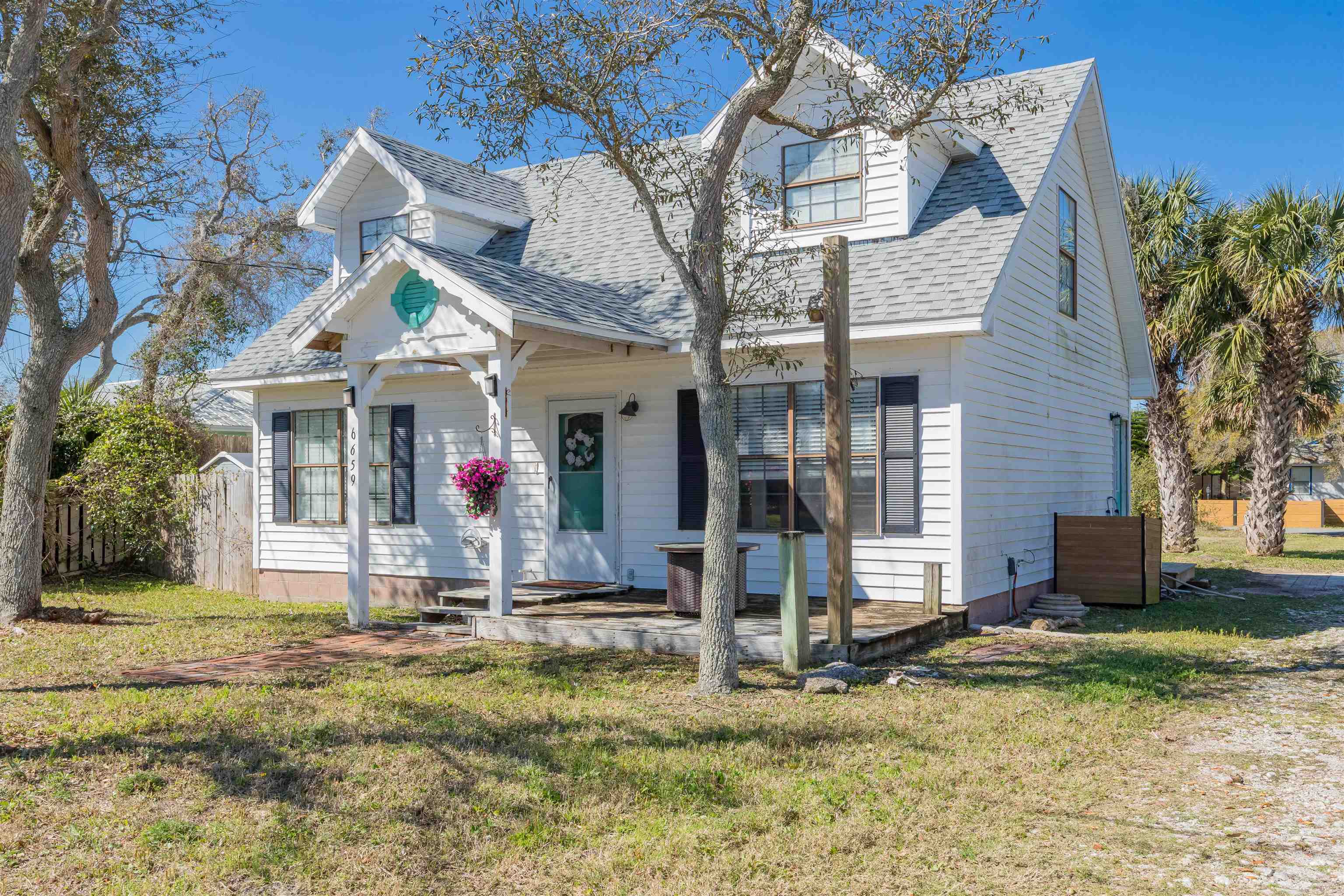 6659 Brevard Street St. Augustine, FL 32080 - Photo 1 of 27 a view of a white house with large windows and a small yard