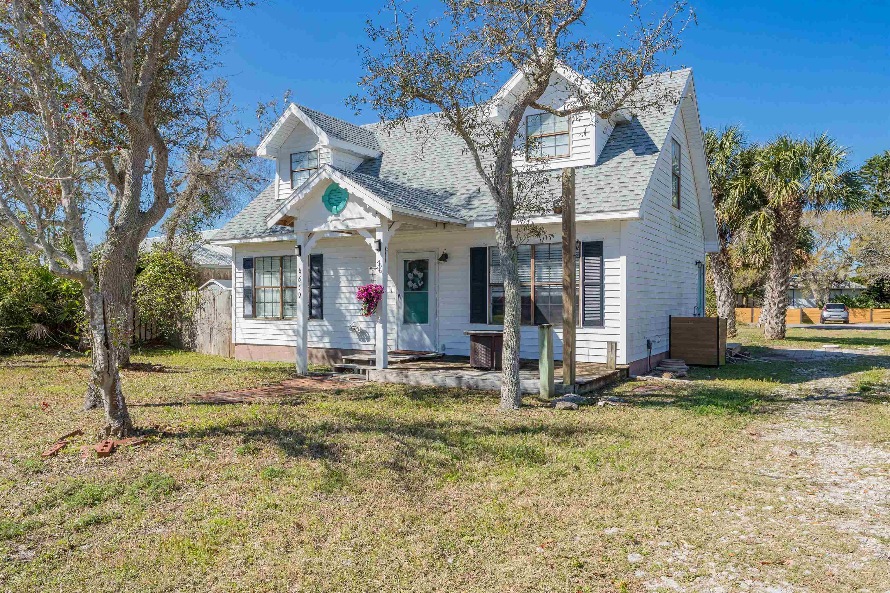 6659 Brevard Street St. Augustine, FL 32080 - Photo 6 of 27 a view of a white house with large windows and a small yard