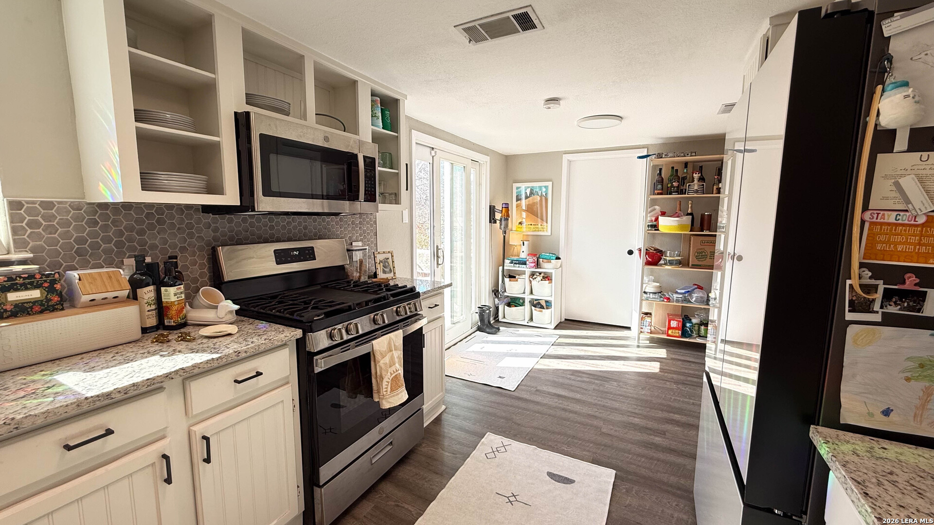 8505 Spring Valley Drive Austin, TX 78736 - Photo 18 of 49 a kitchen with stainless steel appliances granite countertop a stove and a microwave