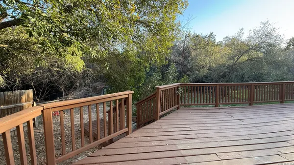 a view of balcony with wooden floor and fence