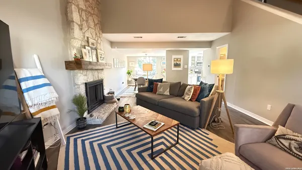 a living room with furniture a fireplace and a chandelier