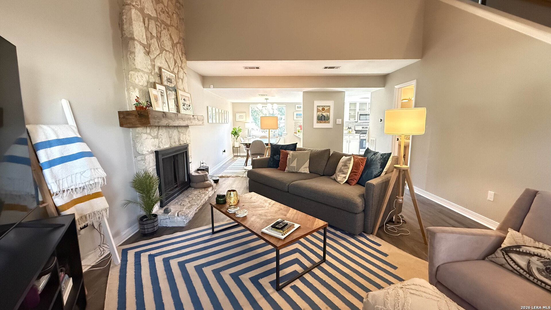 8505 Spring Valley Drive Austin, TX 78736 - Photo 5 of 49 a living room with furniture a fireplace and a chandelier