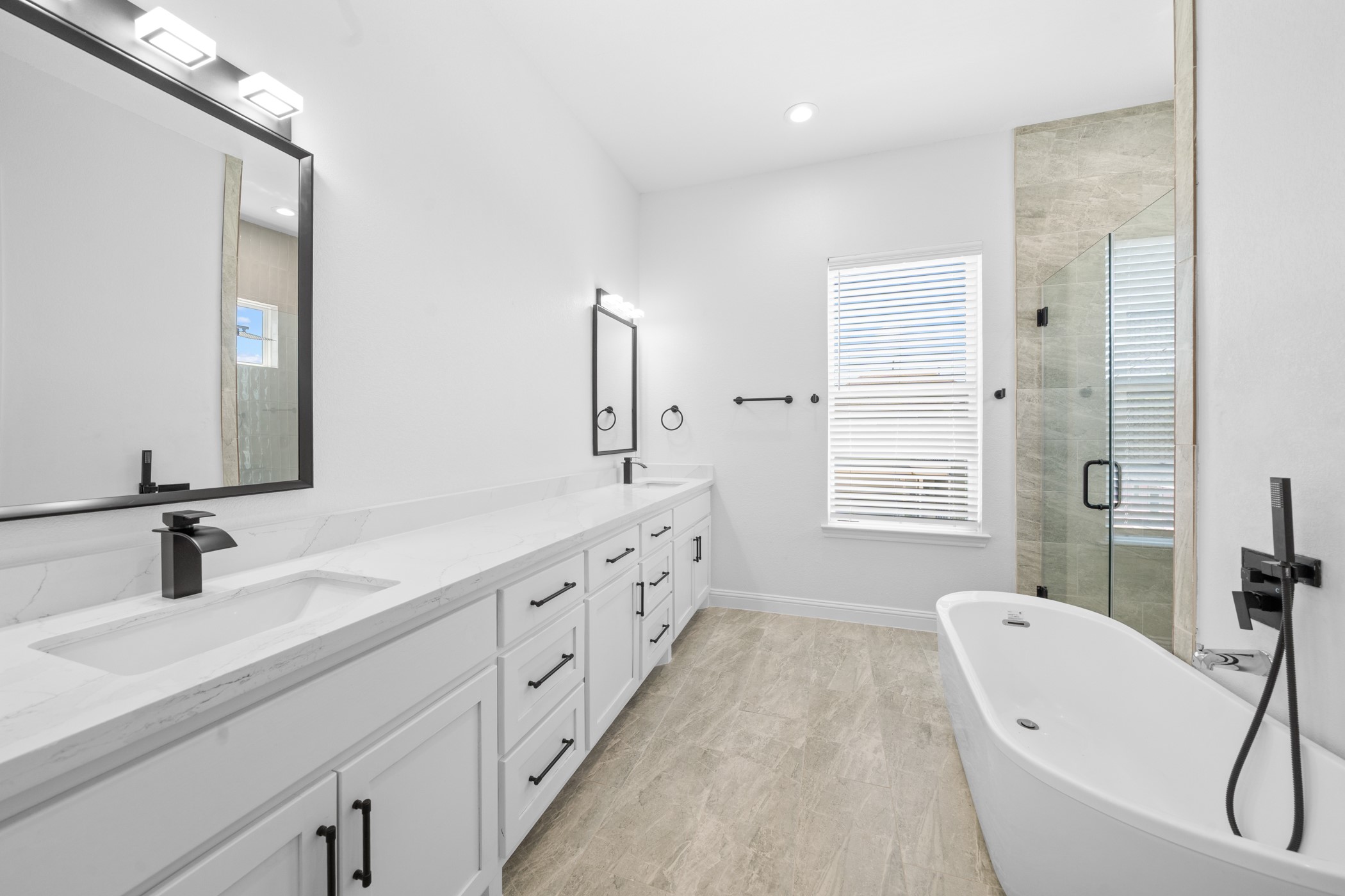 2303 Wipprecht Street Houston, TX 77020 - Photo 11 of 26 a bathroom with double vanity sink a two mirror a window and a bathtub