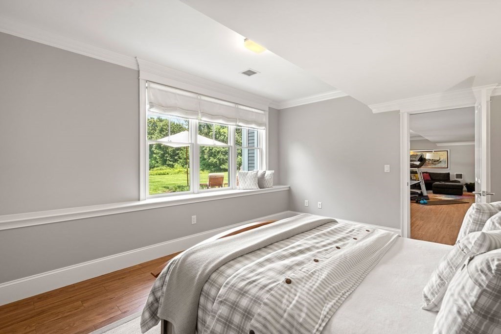 1663 Lowell Road Concord, MA 01742 - Photo 35 of 41 a bedroom with a bed and wooden floor