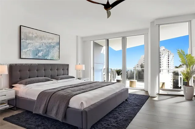 a bedroom with a large bed and a painting on the wall