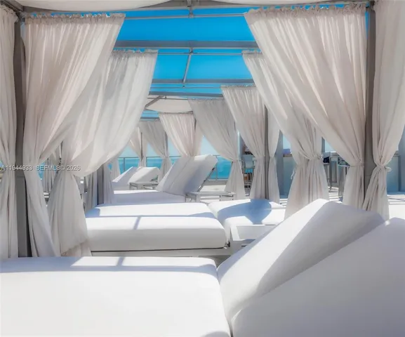 a large kitchen with stainless steel appliances kitchen island granite countertop a refrigerator a stove and a cabinets with wooden floor