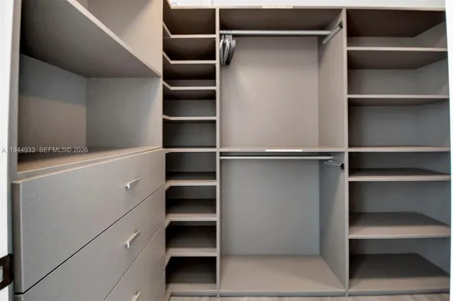 a view of walk in closet with empty racks