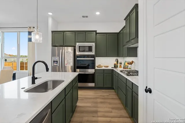 a kitchen with stainless steel appliances granite countertop a sink refrigerator and microwave