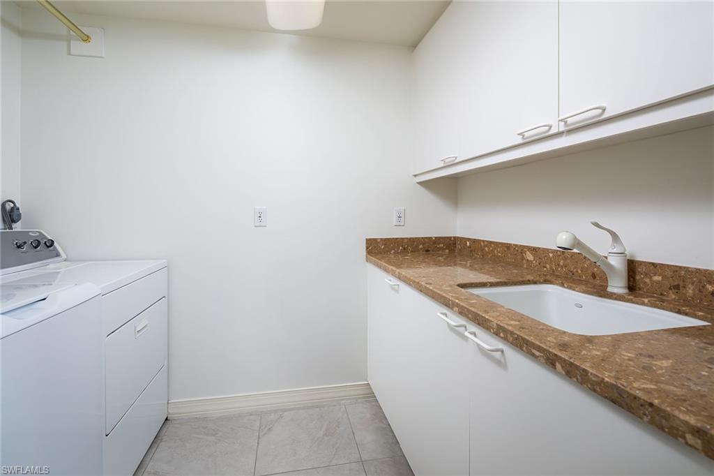 435 Dockside Drive, Unit B703 Naples, FL 34110 - Photo 26 of 38 a bathroom with a granite countertop sink and white cabinets