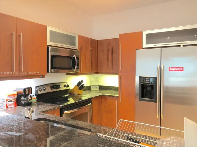 a kitchen with stainless steel appliances granite countertop a refrigerator and a stove top oven