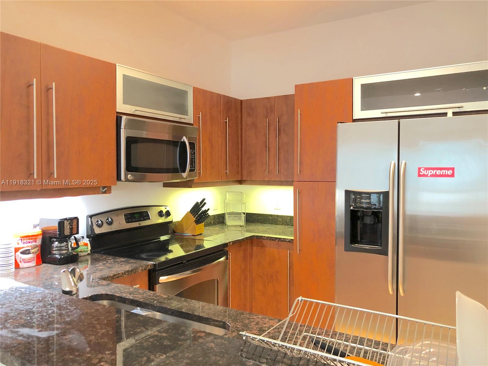 a kitchen with stainless steel appliances granite countertop a refrigerator and a stove top oven