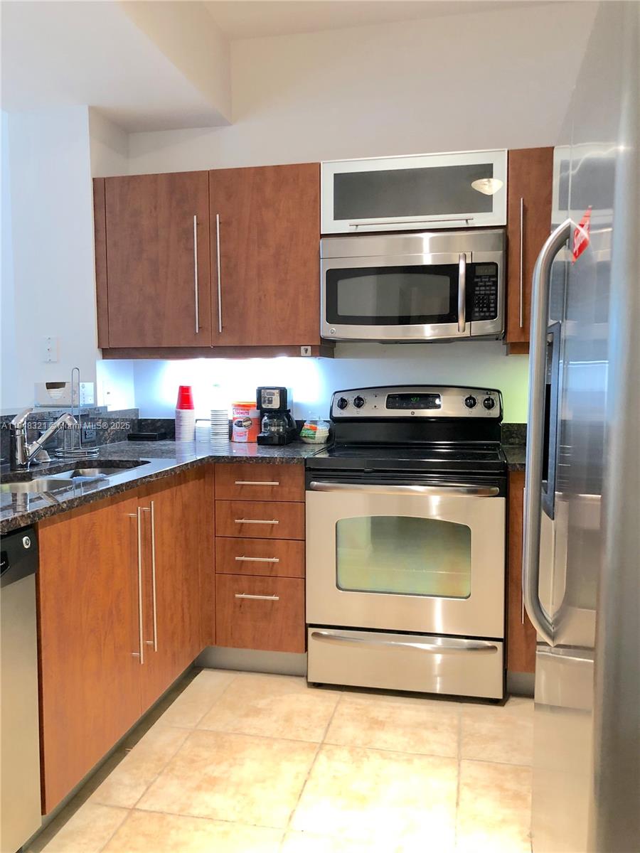 7350 Southwest 89th Street, Unit 408S Miami, FL 33156 - Photo 2 of 19 a kitchen with stainless steel appliances a stove a microwave and a sink