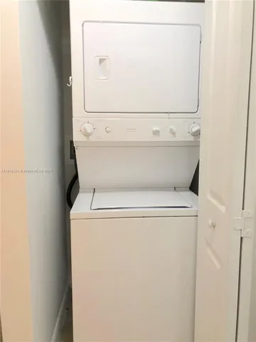 a view of a room with water heater and wooden cabinets