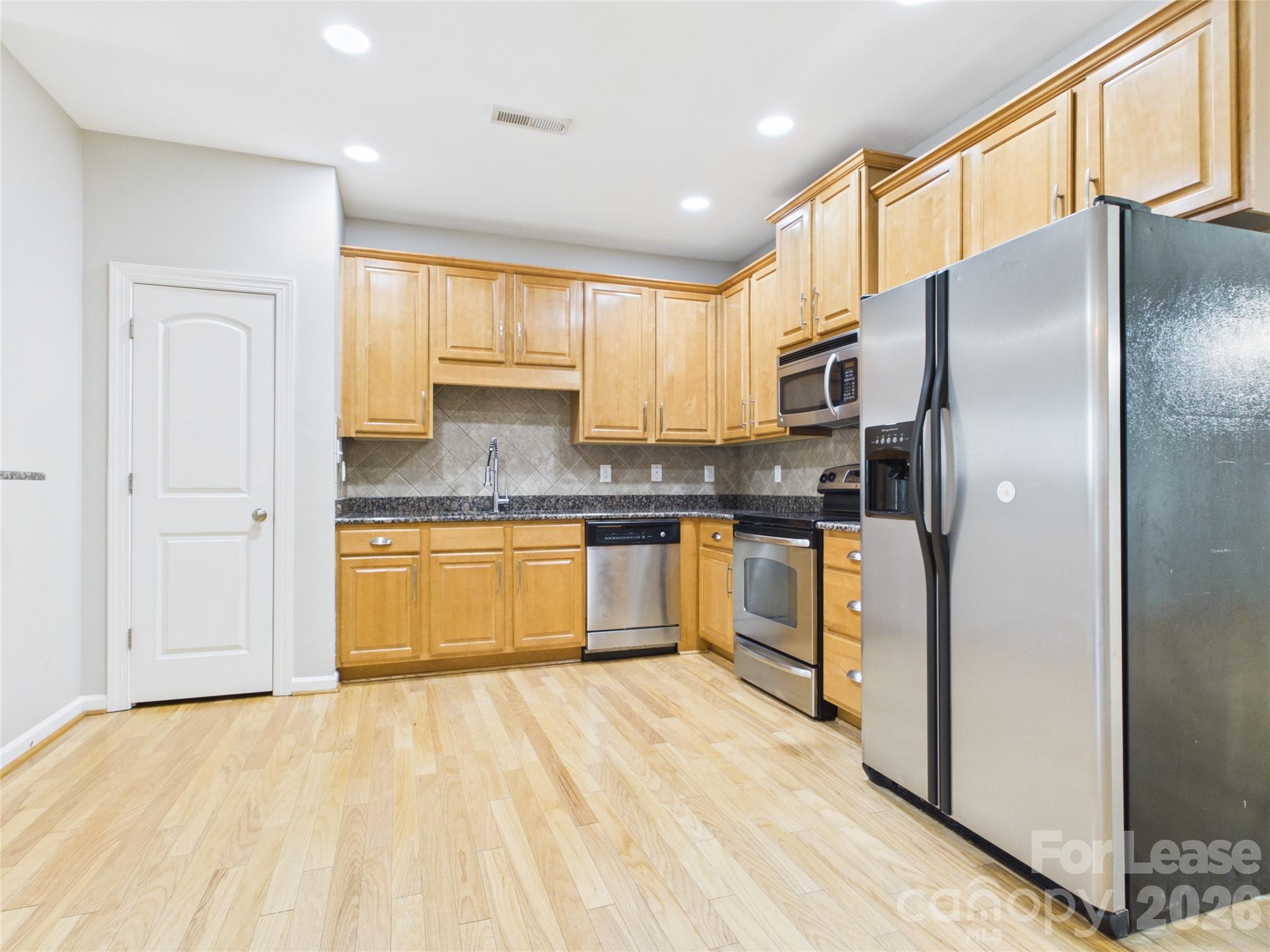 5690 Stafford Road Charlotte, NC 28215 - Photo 4 of 25 a kitchen with stainless steel appliances granite countertop a refrigerator sink and cabinets