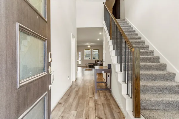 a view of a hallway with wooden floor and staircase