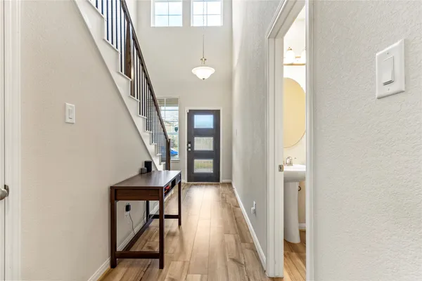 a view of a hallway with wooden floor and staircase