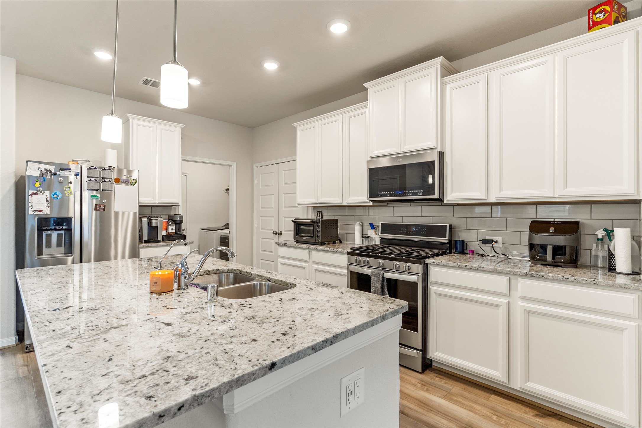 2019 Myrtle Oak Street Conroe, TX 77304 - Photo 7 of 23 a kitchen with a stove a sink a refrigerator and chairs