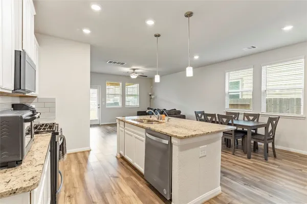 a kitchen with a stove a table and chairs