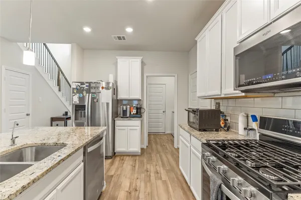a kitchen with a sink stove top oven and refrigerator