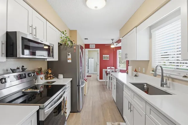 a kitchen with stainless steel appliances a sink stove microwave and refrigerator