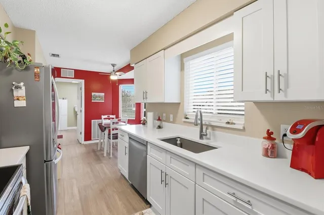 a kitchen with stainless steel appliances granite countertop a sink dishwasher stove and refrigerator