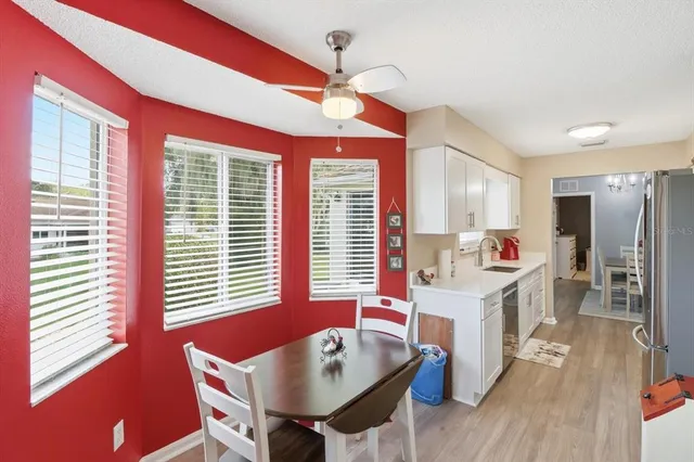 a living room with kitchen island furniture a wooden floor and a chandelier