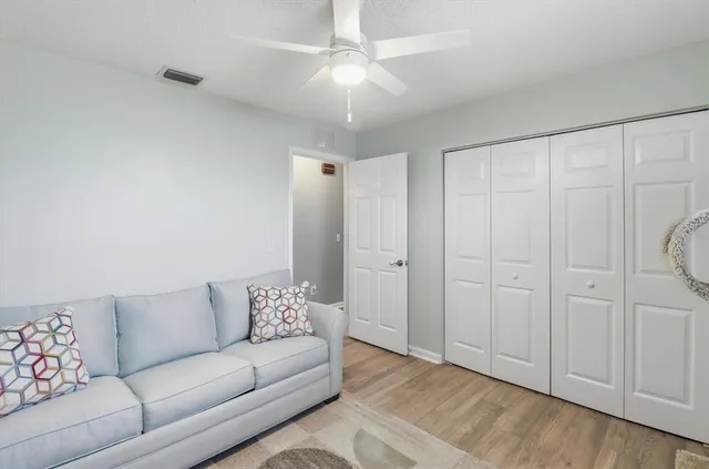 a living room with furniture and a ceiling fan