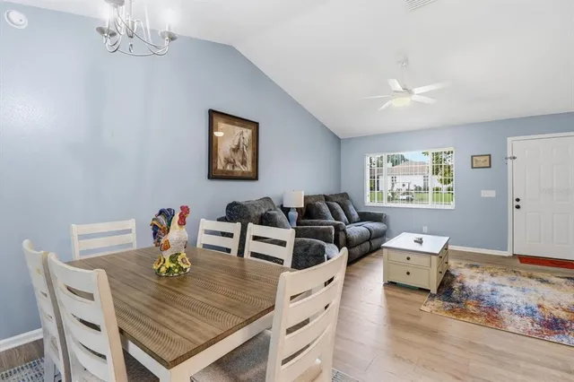 a view of a dining room with furniture a chandelier and wooden floor