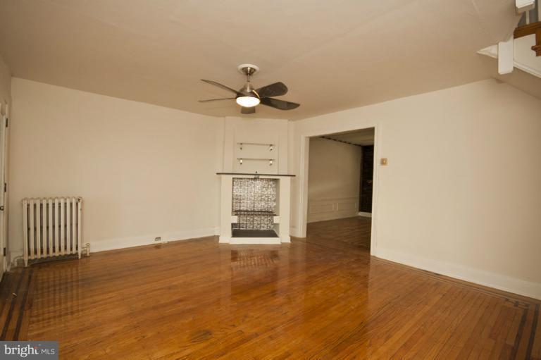 3629 Yolando Road Baltimore, MD 21218 - Photo 8 of 18 a view of an empty room with wooden floor and a ceiling fan