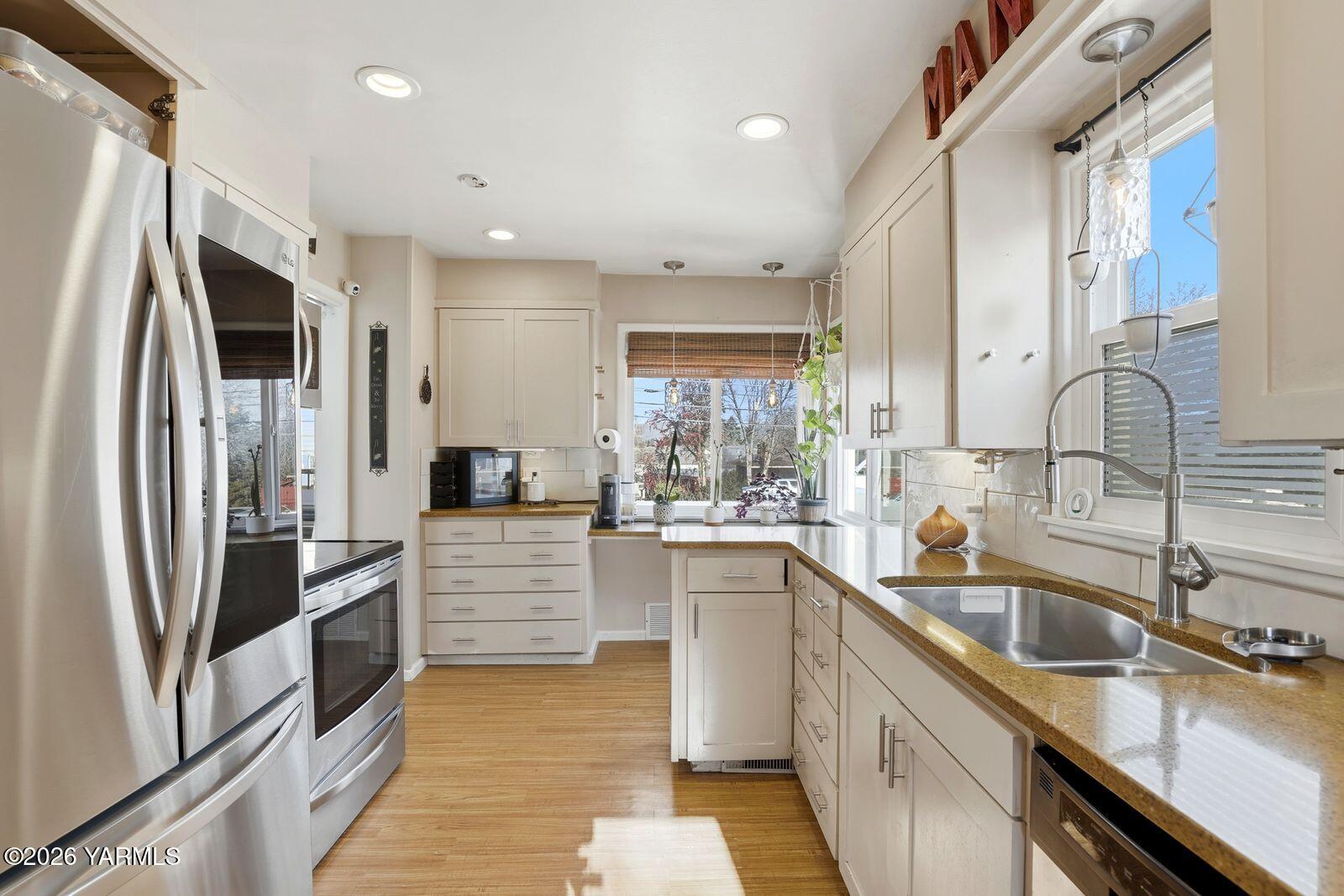 a kitchen with stainless steel appliances sink a stove and refrigerator