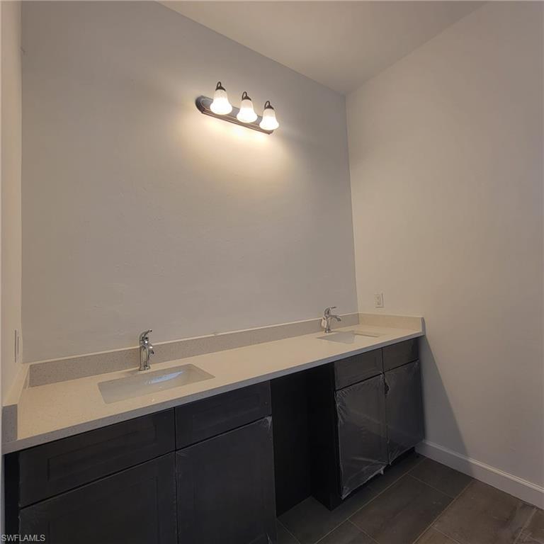 1900 West 16th Street Lehigh Acres, FL 33972 - Photo 15 of 21 a bathroom with a sink and a mirror