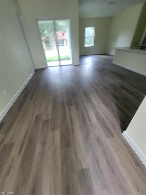 1900 West 16th Street Lehigh Acres, FL 33972 - Photo 6 of 21 a view of empty room with wooden floor and fan