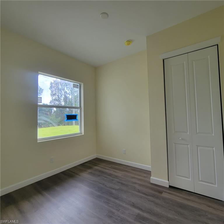 1900 West 16th Street Lehigh Acres, FL 33972 - Photo 8 of 21 an empty room with wooden floor and windows