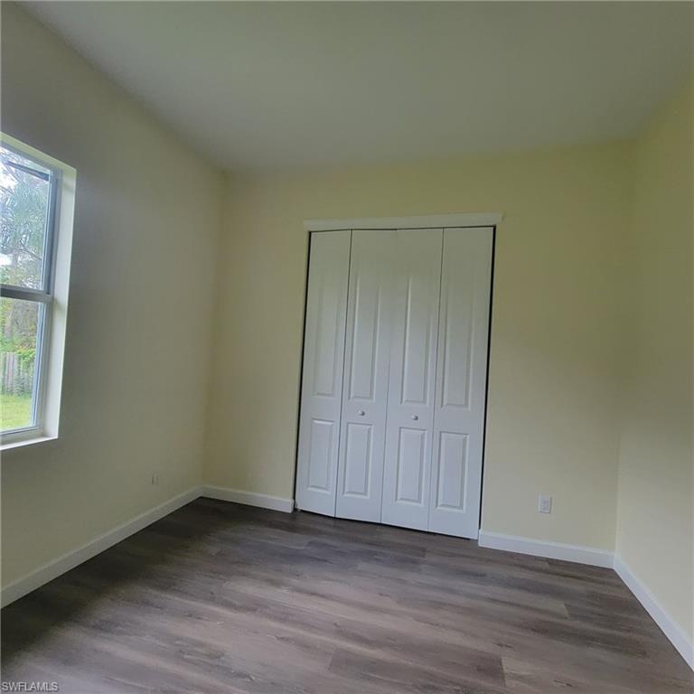 1900 West 16th Street Lehigh Acres, FL 33972 - Photo 9 of 21 a view of an empty room with wooden floor and a window
