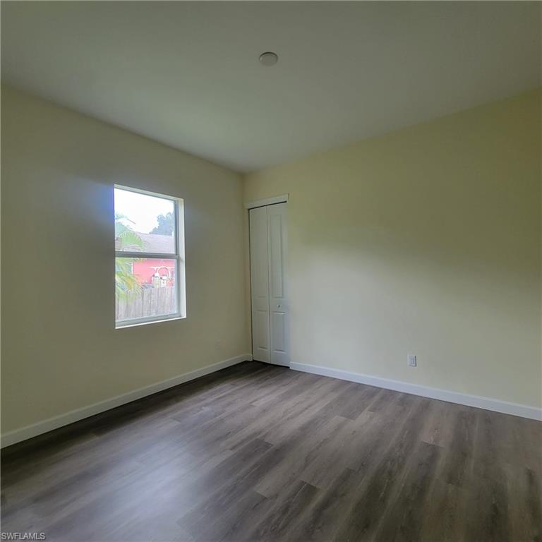 1900 West 16th Street Lehigh Acres, FL 33972 - Photo 10 of 21 an empty room with wooden floor and windows