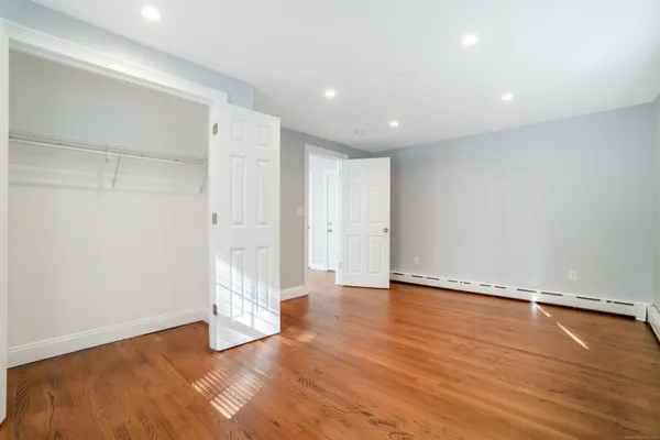 a view of an empty room with wooden floor