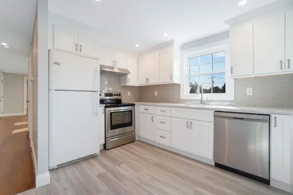 a kitchen with granite countertop white cabinets and white appliances
