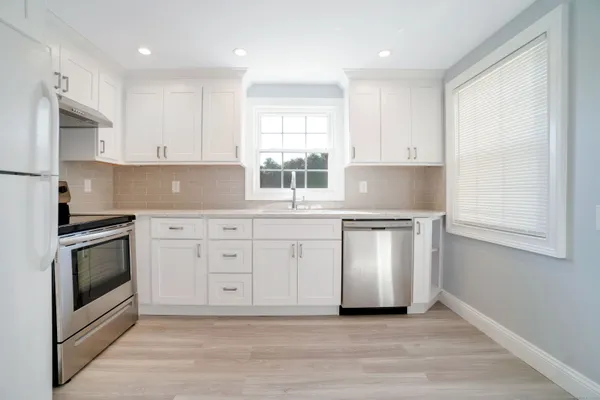 a kitchen with stainless steel appliances granite countertop a stove a sink and a microwave