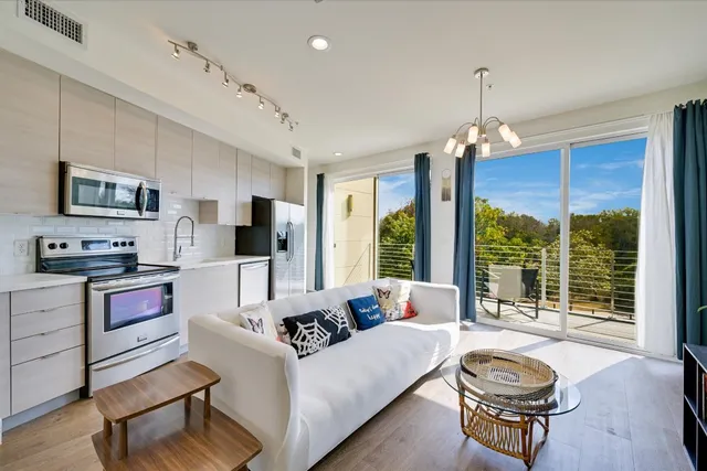 a living room with furniture flat screen tv and a large window