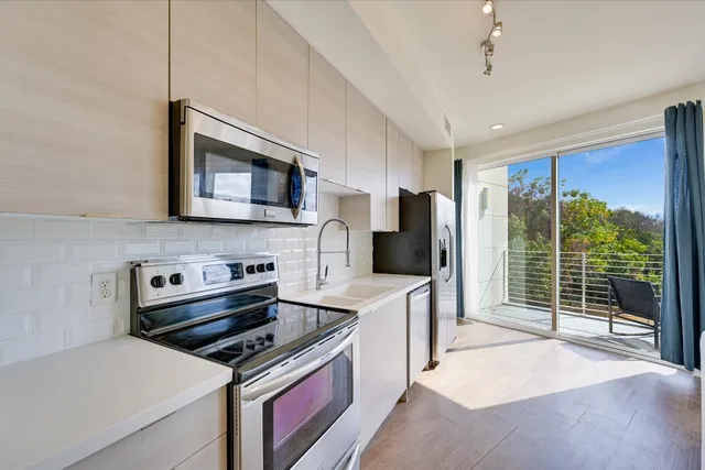 a kitchen with stainless steel appliances a stove sink microwave and refrigerator