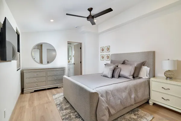 a bedroom with a bed a mirror and on the dresser