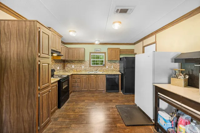 a kitchen with stainless steel appliances granite countertop a refrigerator a stove top oven a sink and dishwasher