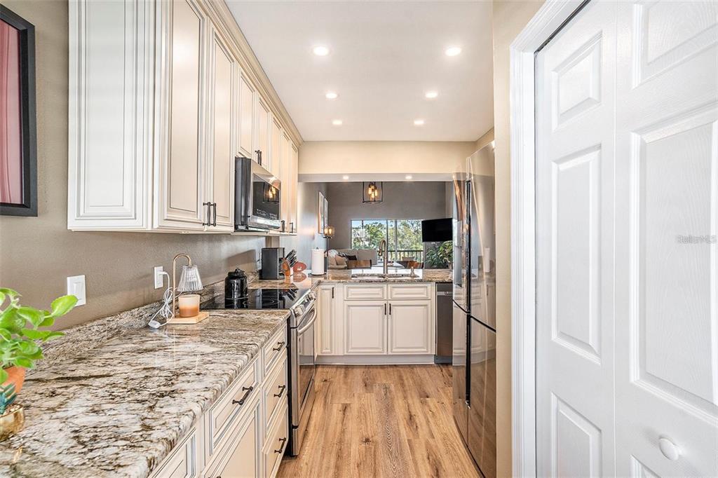 8210 Aquila Street, Unit 223 Port Richey, FL 34668 - Photo 11 of 36 a kitchen with stainless steel appliances granite countertop a refrigerator sink and white cabinets