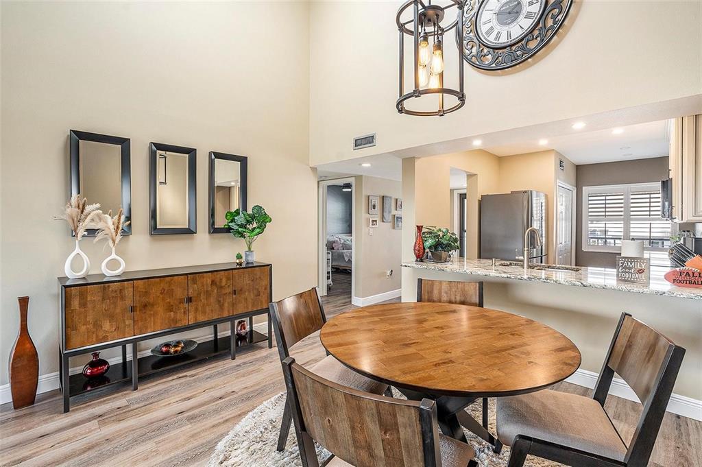 8210 Aquila Street, Unit 223 Port Richey, FL 34668 - Photo 17 of 36 a dining room with wooden floor a chandelier a wooden table and chairs