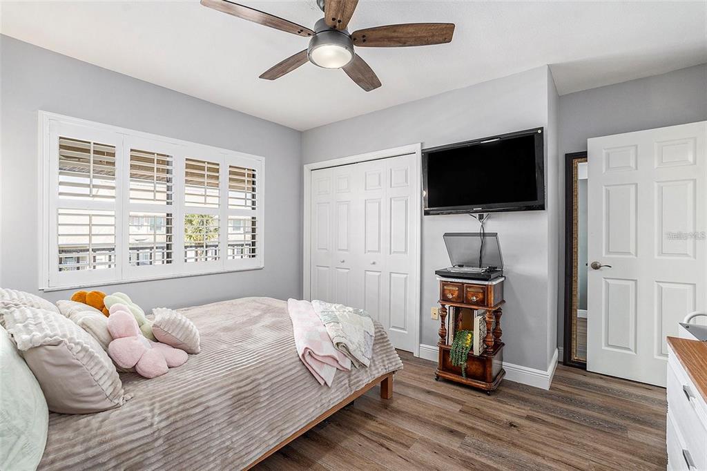 8210 Aquila Street, Unit 223 Port Richey, FL 34668 - Photo 24 of 36 a bedroom with a bed a flat screen tv and a window