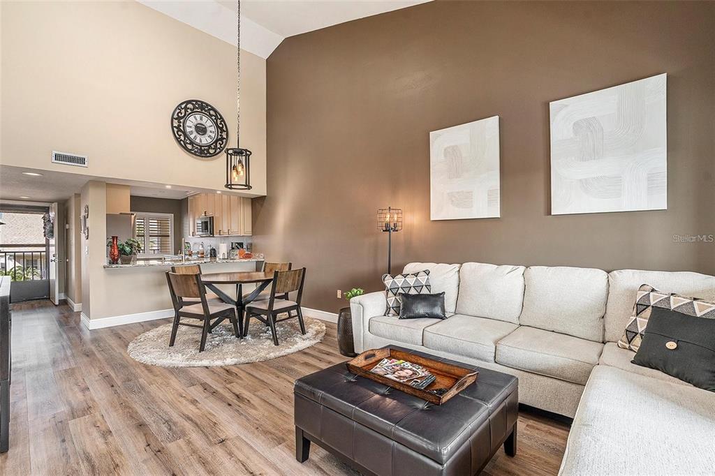 8210 Aquila Street, Unit 223 Port Richey, FL 34668 - Photo 8 of 36 a living room with furniture a clock on wall and a table
